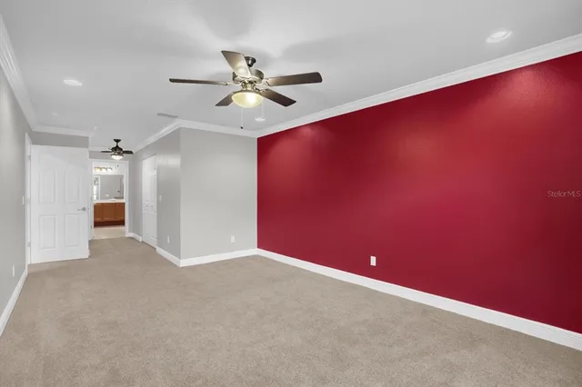 an empty room with closet and a chandelier fan