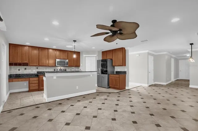 a kitchen with stainless steel appliances kitchen island granite countertop a sink a stove and cabinets