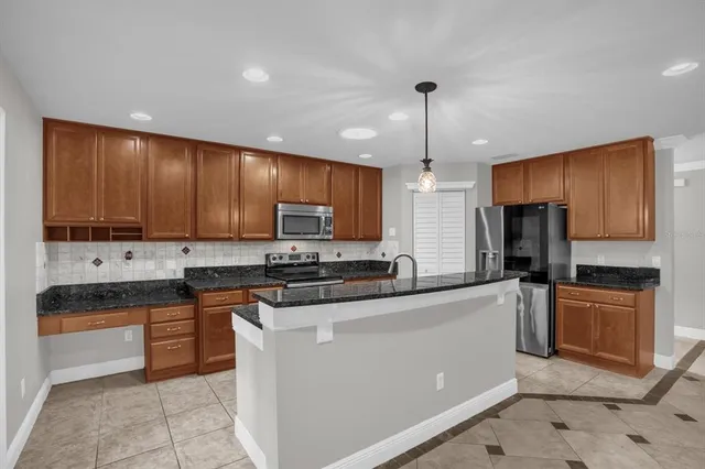 a kitchen with stainless steel appliances granite countertop refrigerator a stove top oven a sink and dishwasher