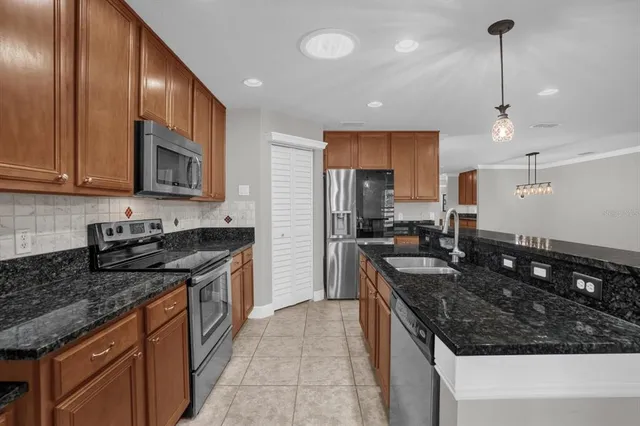 a kitchen with stainless steel appliances granite countertop a sink stove and refrigerator