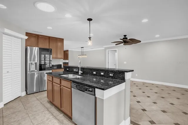 a kitchen with stainless steel appliances granite countertop a sink a stove a refrigerator and cabinets