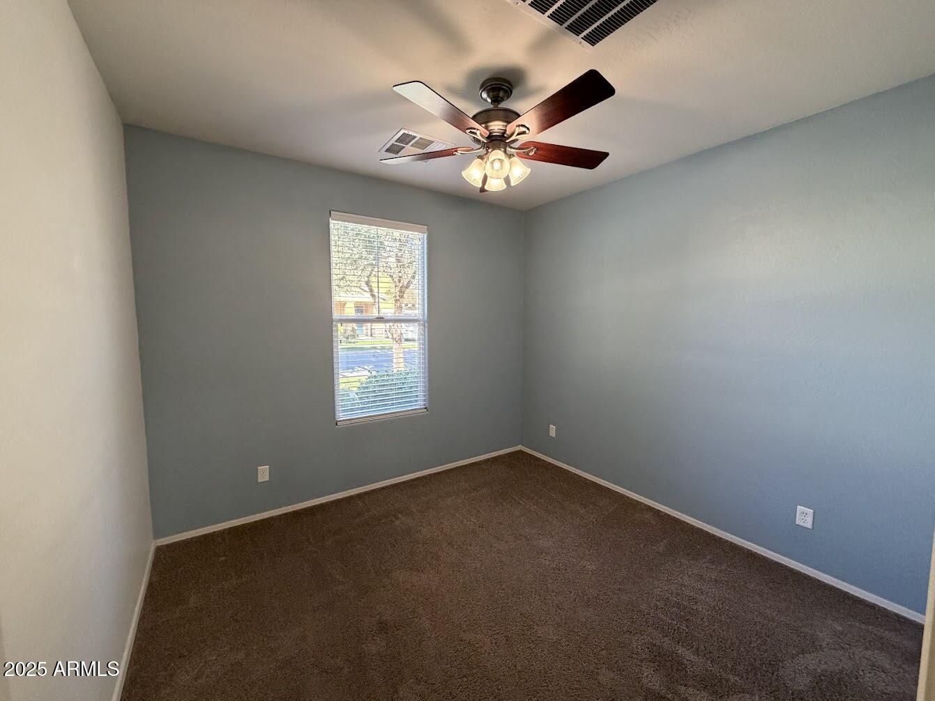 3349 East Cheyenne Street Gilbert, AZ 85296 - Photo 11 of 18 an empty room with a chandelier fan and windows