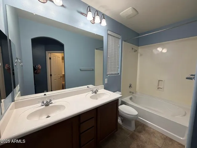 a bathroom with a double vanity sink toilet mirror and bathtub