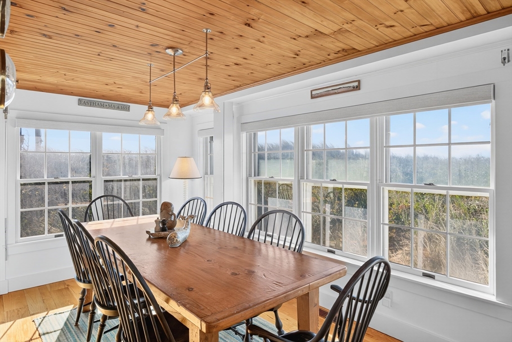 1145 Kingsbury Beach Road Eastham, MA 02642 - Photo 21 of 42 a view of a dining room with furniture window and outside view