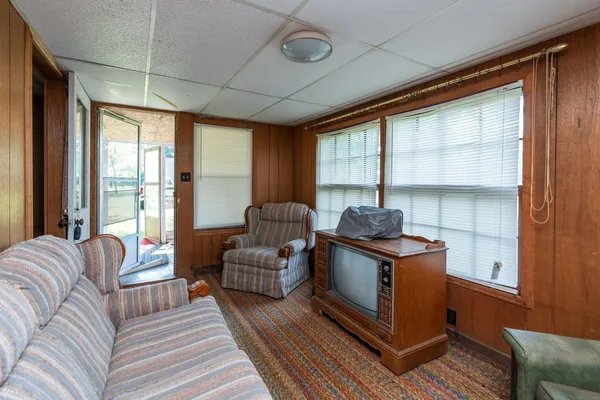 a living room with furniture a flat screen tv and large window
