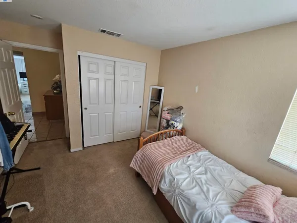 a bed sitting in a bedroom next to a window