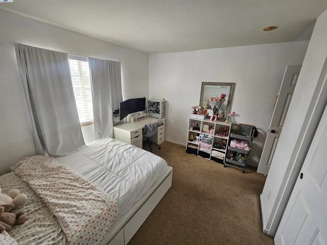 a bedroom with a bed a couch and a window