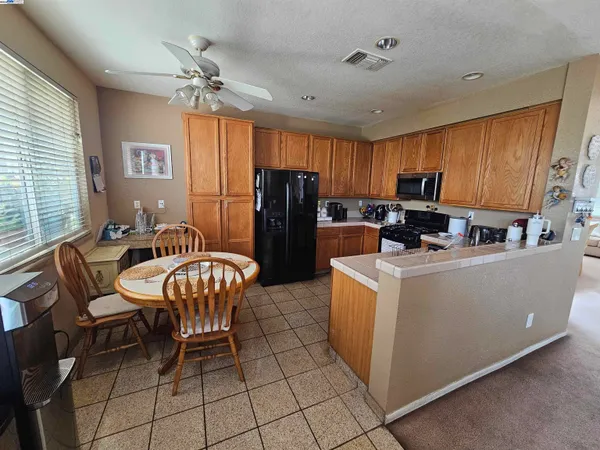 a kitchen with granite countertop a table chairs refrigerator and microwave