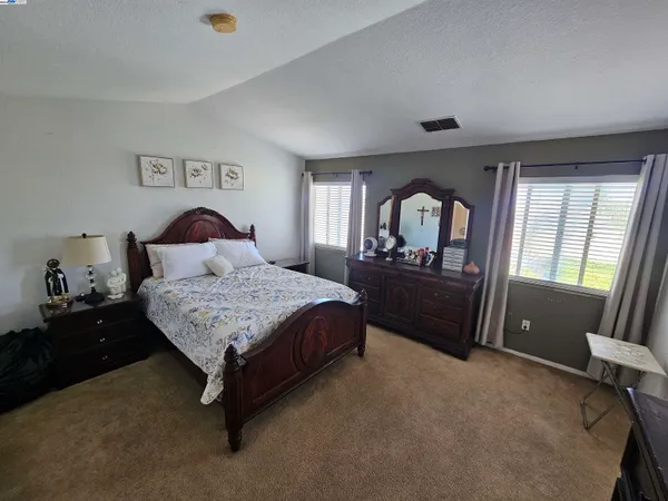 a bedroom with a bed and a large window