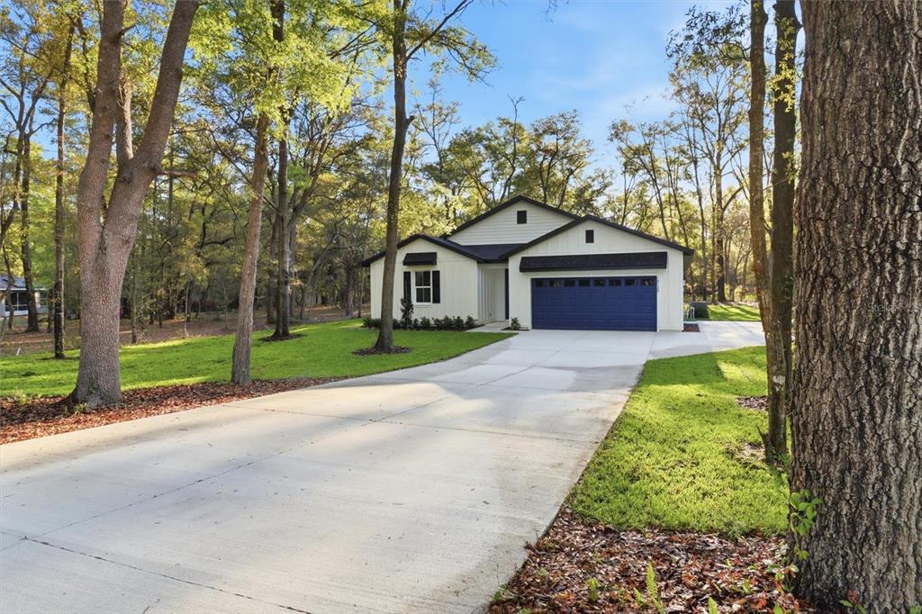19126 Southwest 101st Street Dunnellon, FL 34432 - Photo 2 of 46 a front view of a house with a garden and trees