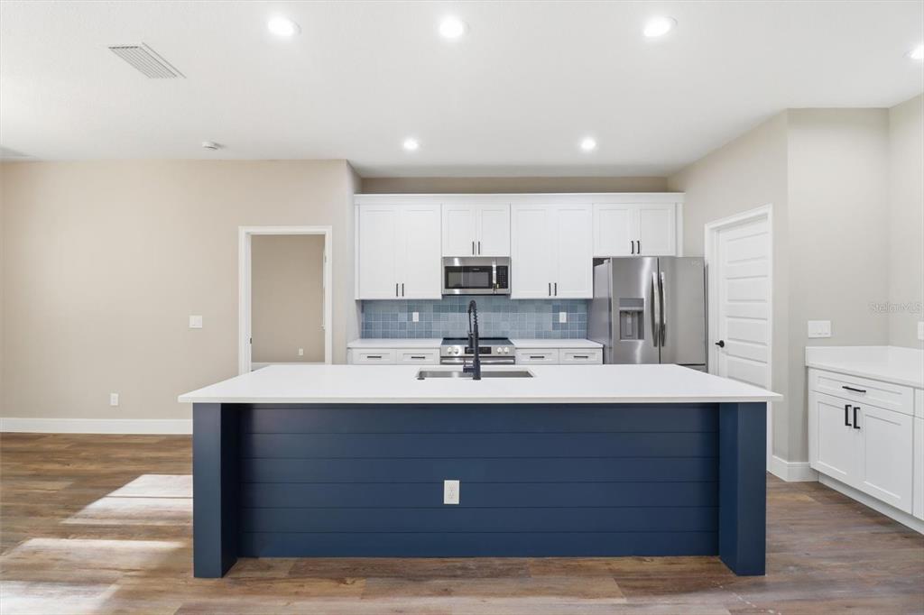19126 Southwest 101st Street Dunnellon, FL 34432 - Photo 7 of 46 a view with kitchen island a sink stainless steel appliances and cabinets
