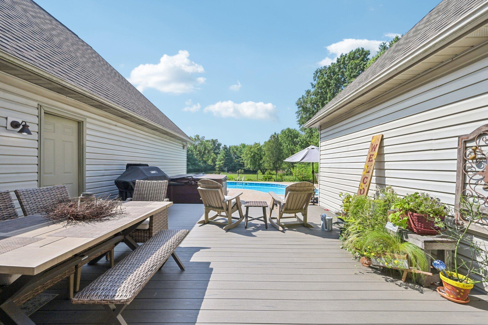 7700 Plumb Road Galena, OH 43021 - Photo 15 of 94 Relax and unwind on this sunny deck with views of the sparkling pool and private, tree-lined backyard.