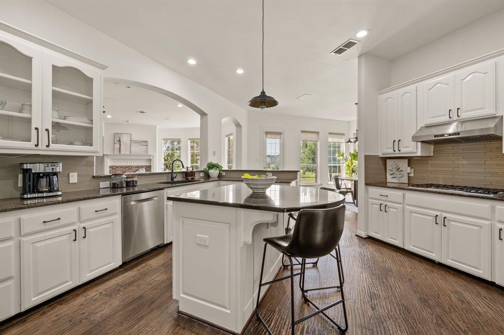 2038 Azalea Trail Irving, TX 75063 - Photo 16 of 39 a kitchen with stainless steel appliances granite countertop a white cabinets and wooden floor