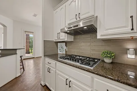 a kitchen with stainless steel appliances granite countertop a sink stove and cabinets