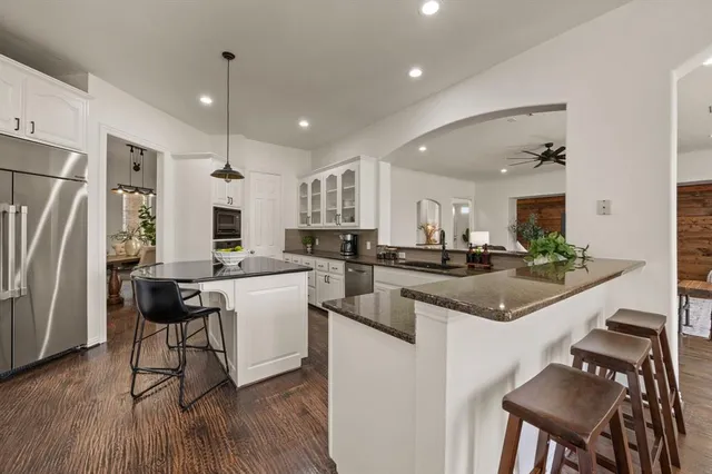 a kitchen with a sink a counter top space stainless steel appliances and cabinets