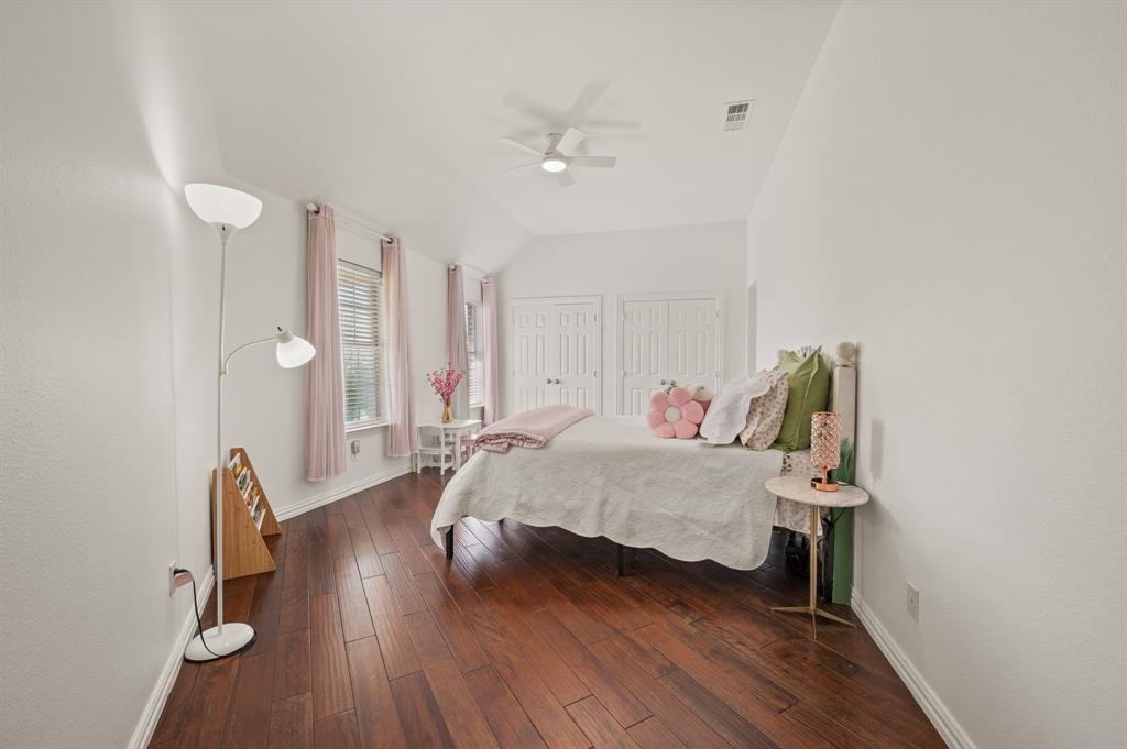 2038 Azalea Trail Irving, TX 75063 - Photo 29 of 39 a spacious bedroom with a bed and a chandelier