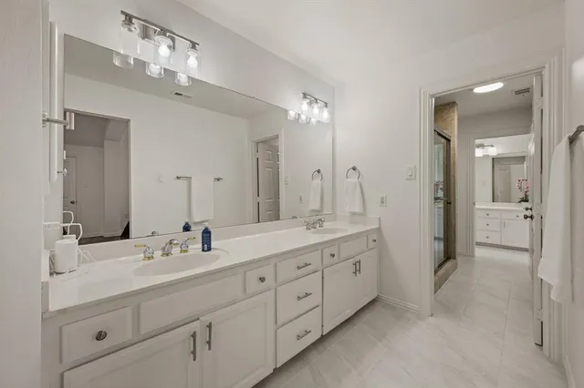 a spacious bathroom with a double vanity sink mirror double and shower