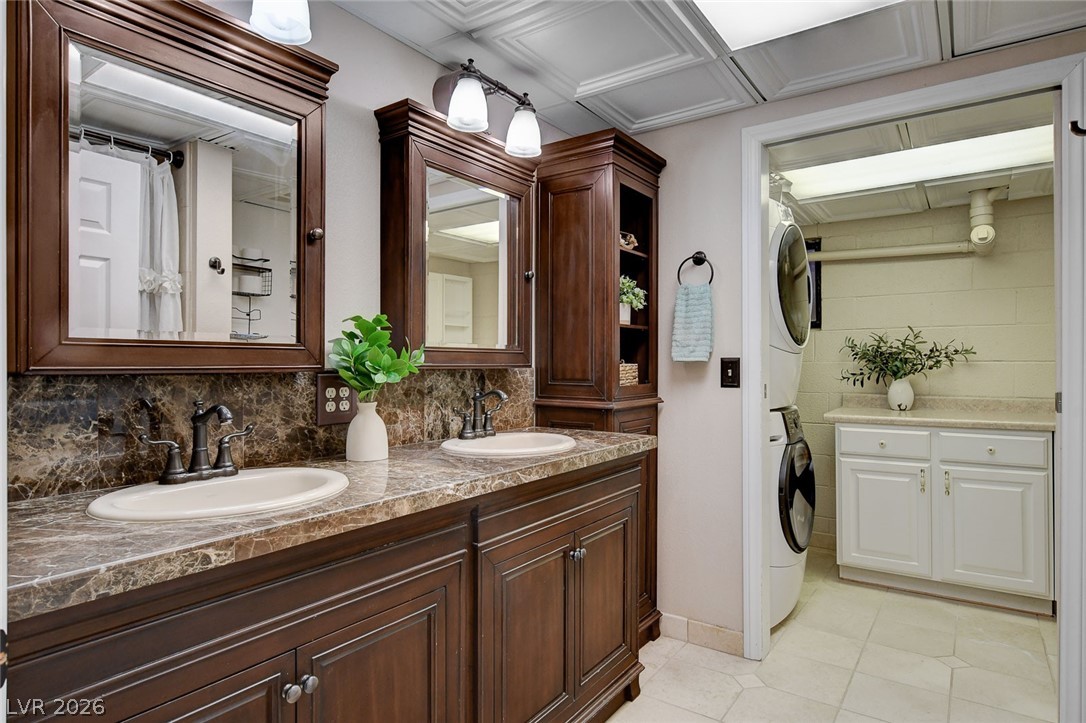 3765 Berkeley Street Logandale, NV 89021 - Photo 57 of 87 This bathroom features a double vanity with rich cabinetry and an adjoining laundry area for convenience.