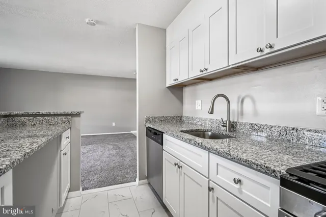 a kitchen with granite countertop a sink and cabinets