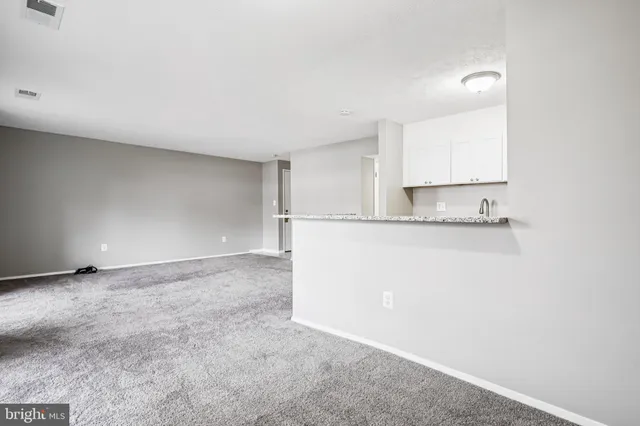 a view of kitchen with granite countertop cabinets and sink