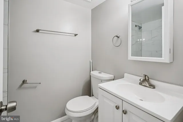 a bathroom with a sink a toilet a mirror and shower