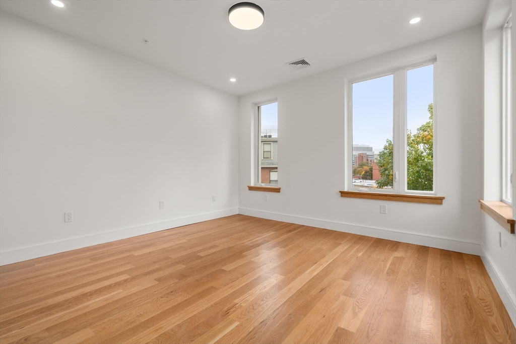 58 Kent, Unit 301 Brookline, MA 02445 - Photo 16 of 24 an empty room with wooden floor and windows