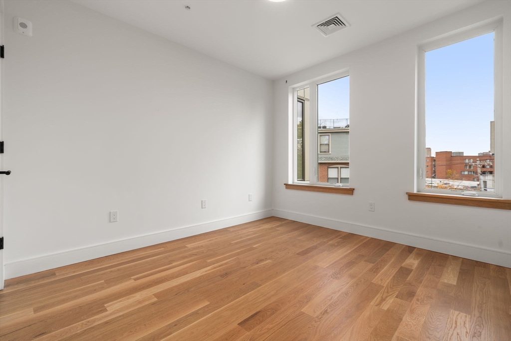 58 Kent, Unit 301 Brookline, MA 02445 - Photo 18 of 24 a view of an empty room with wooden floor and a window