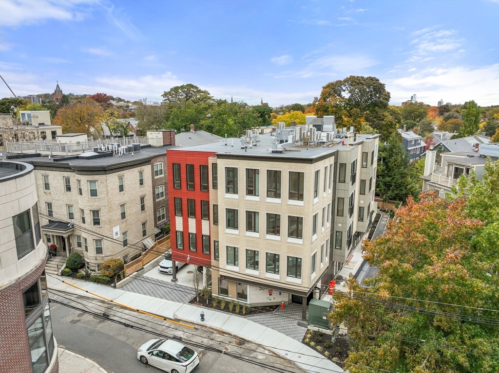 58 Kent, Unit 301 Brookline, MA 02445 - Photo 22 of 24 a view of a building with a yard and potted plants