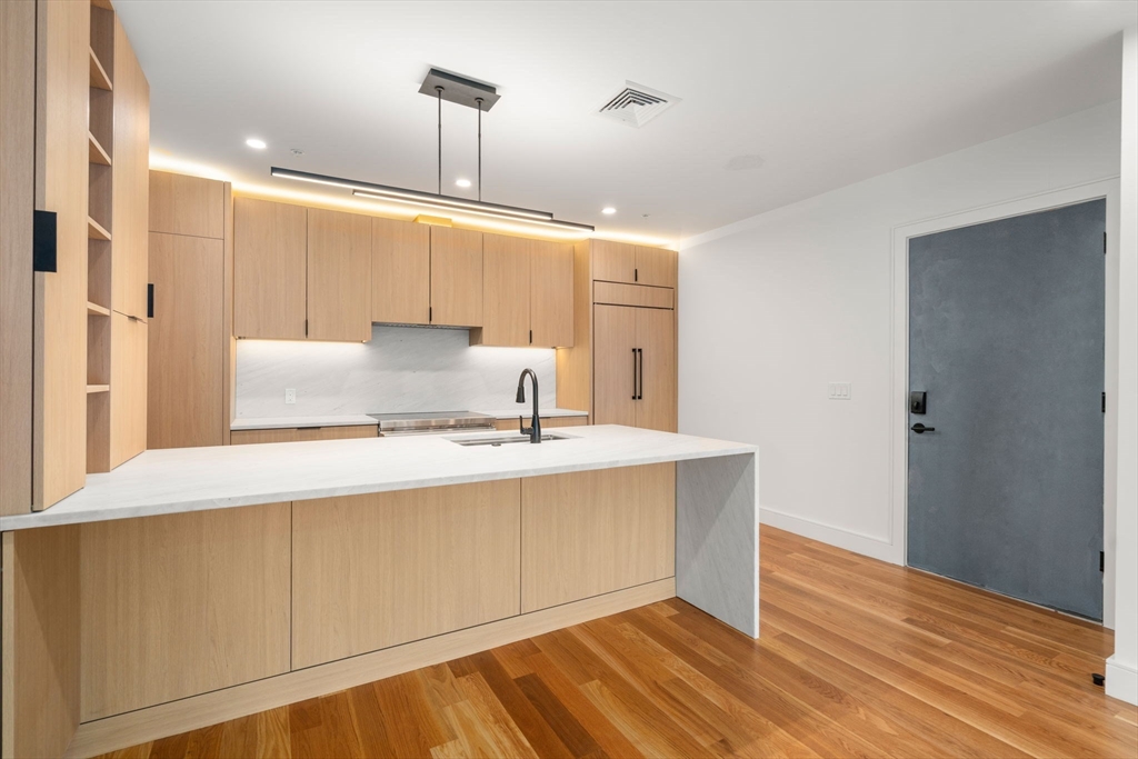 58 Kent, Unit 301 Brookline, MA 02445 - Photo 5 of 24 a view of kitchen with wooden floor