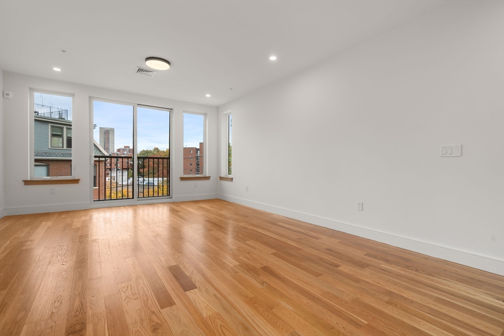 58 Kent, Unit 301 Brookline, MA 02445 - Photo 7 of 24 a view of an empty room with a window and wooden floor