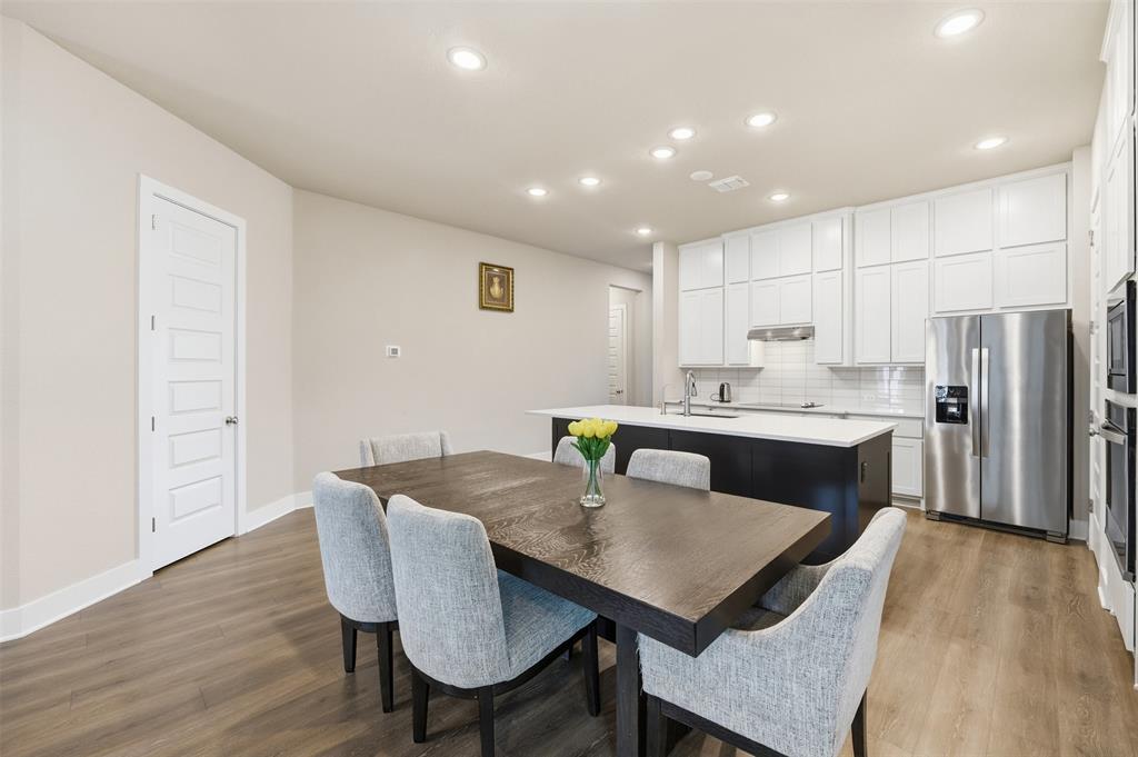 5805 Heatherwood Loop Sachse, TX 75048 - Photo 13 of 39 a kitchen with a dining table chairs and wooden floor