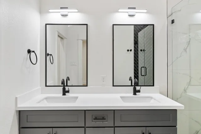 a bathroom with double vanity sinks and a mirror