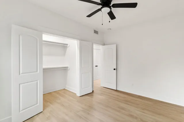 a view of a room with wooden floor and ceiling fan