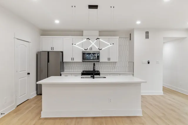 a view of kitchen with refrigerator sink and wooden floor
