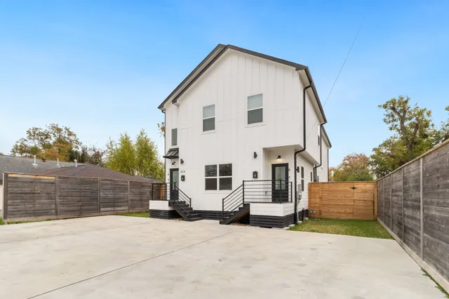 a view of a white house with a yard and garage