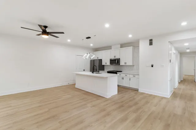a view of kitchen with stainless steel appliances refrigerator stove microwave and cabinets