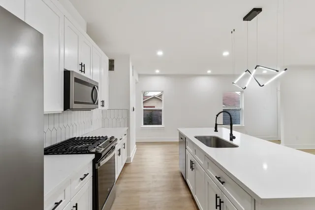 a kitchen with stainless steel appliances a sink stove and refrigerator