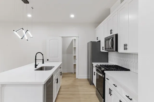 a kitchen with stainless steel appliances a sink and a refrigerator