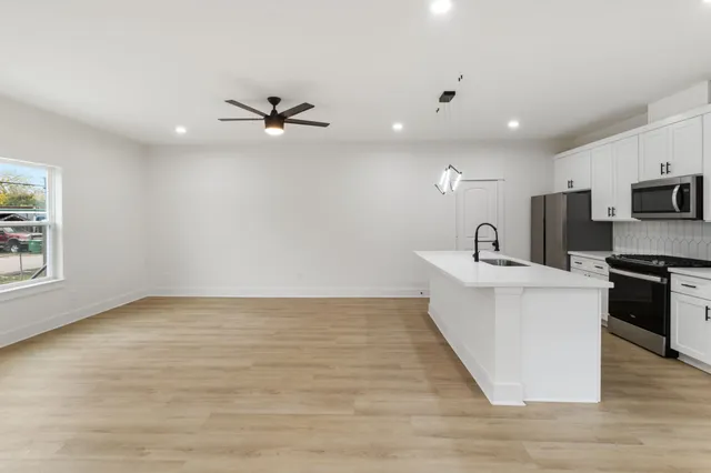 a view of a kitchen with sink and microwave