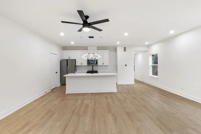 a view of kitchen with stainless steel appliances kitchen island a sink and a stove