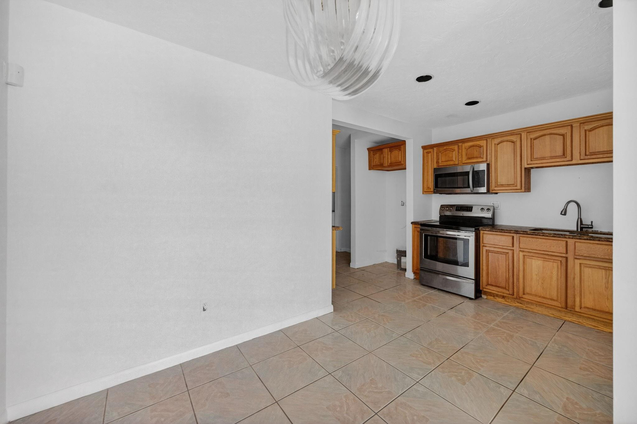 11720 Southwest 176th Street Miami, FL 33177 - Photo 15 of 31 a kitchen with stainless steel appliances a stove top oven a sink a microwave and a refrigerator