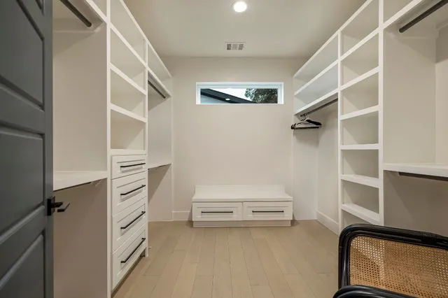 a view of walk in closet with empty racks