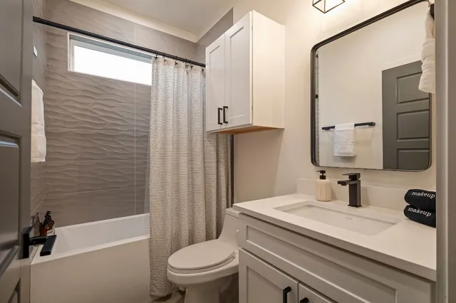 a bathroom with a granite countertop sink toilet a mirror and shower