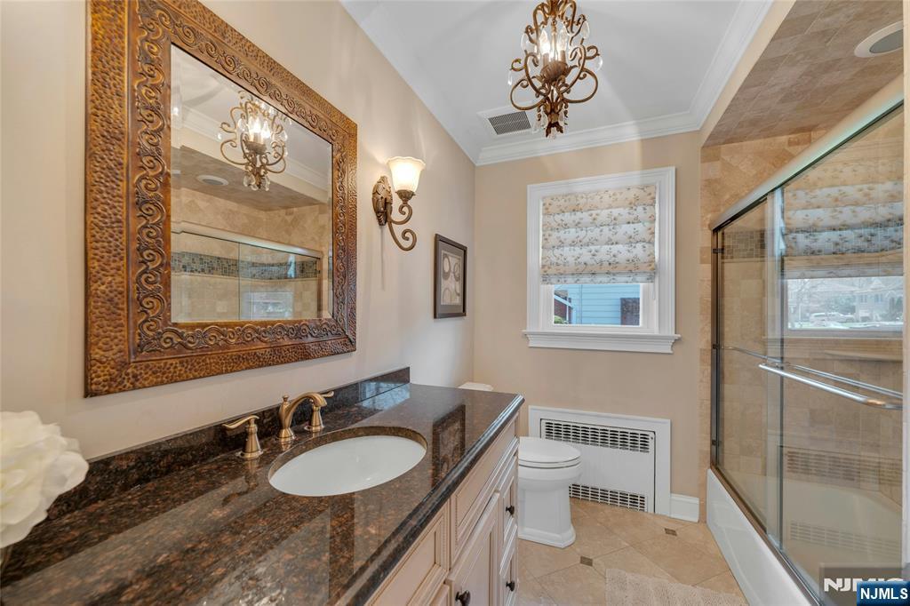 117 Wanamaker Avenue Oradell, NJ 07649 - Photo 31 of 49 a bathroom with a granite countertop sink a mirror a vanity and a shower