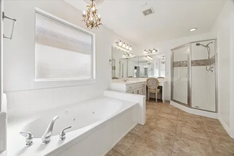 a spacious bathroom with a tub sink and a mirror