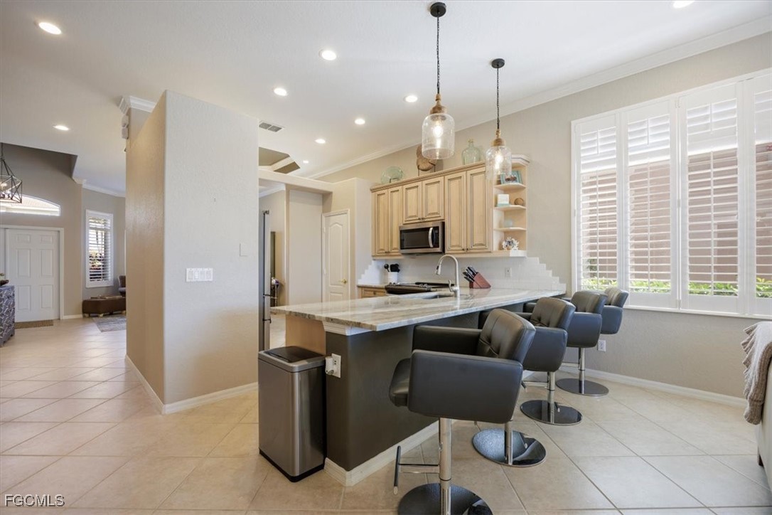 9159 Spring Mountain Way Fort Myers, FL 33908 - Photo 14 of 48 a kitchen with stainless steel appliances kitchen island granite countertop a sink and a refrigerator
