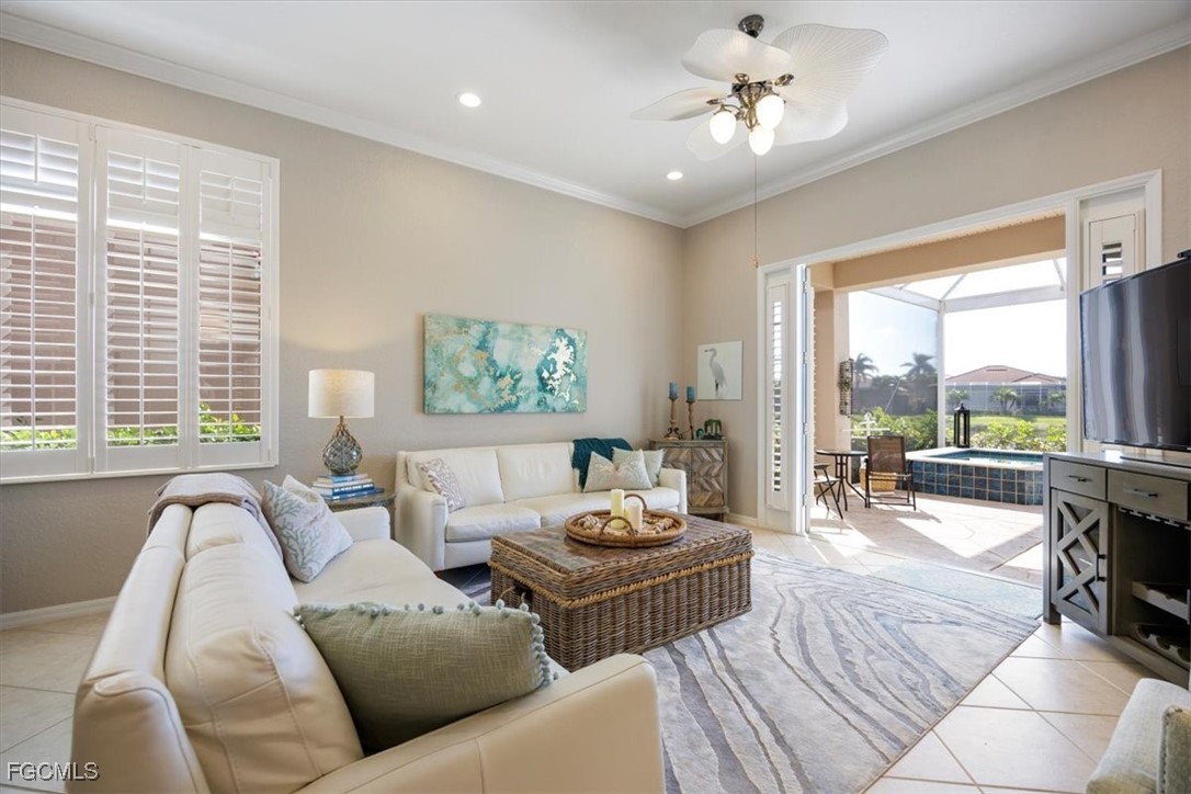 9159 Spring Mountain Way Fort Myers, FL 33908 - Photo 18 of 48 a living room with furniture and a large window with garden view