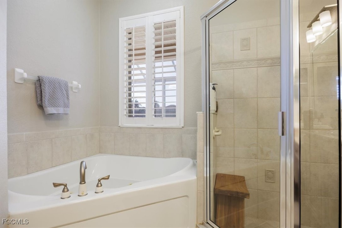 9159 Spring Mountain Way Fort Myers, FL 33908 - Photo 30 of 48 a bathroom with a tub and shower