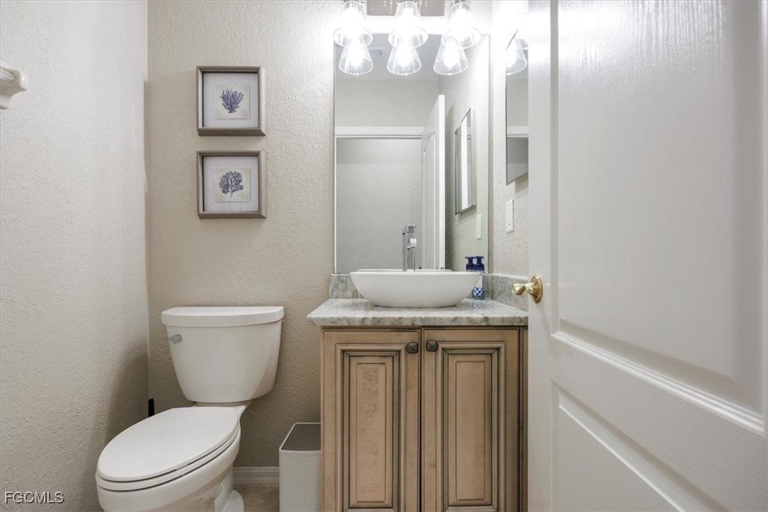 9159 Spring Mountain Way Fort Myers, FL 33908 - Photo 32 of 48 a bathroom with a granite countertop toilet sink and mirror