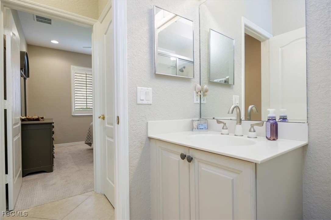 9159 Spring Mountain Way Fort Myers, FL 33908 - Photo 34 of 48 a bathroom with a sink a toilet and mirror